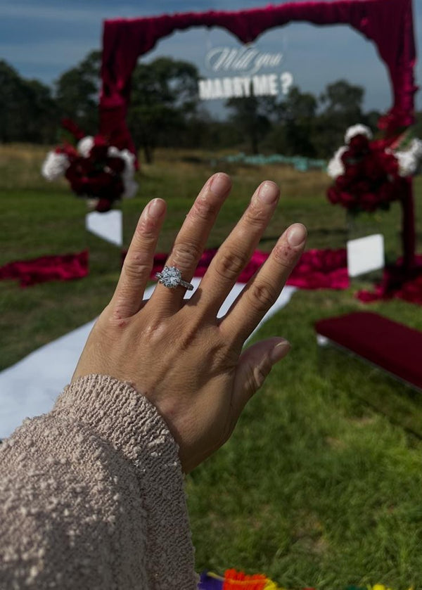 Eluri customer wearing a round lab grown diamond engagement ring with side stones at her proposal